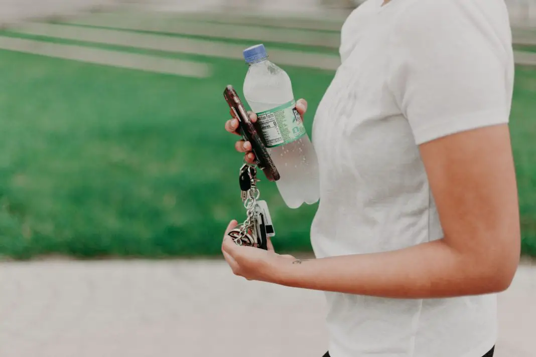 一名女子携带一次性水瓶、电话和钥匙孔侑dF4y2Ba
