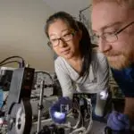 化学工程和材料科学博士生Yimu Zhao和化学工程和材料科学助理教授Richard Lunt在Lunt的实验室进行了一项测试。